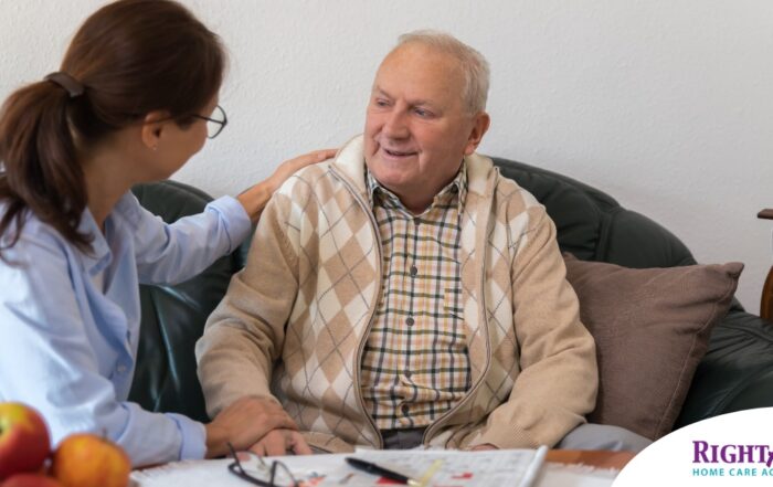 A caregiver compassionately listens to an older man, representing the kind of patience and empathy that help with communicating with clients who have dementia.