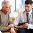 An older man talks with a doctor representing the effective communication that family caregivers should endeavor to have.